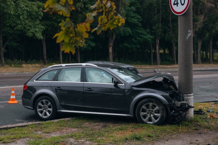 Broken bumper and hood of a car as a result of a collision with a pole,